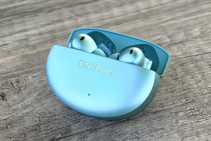OnePlus Buds 4 on a table with case open.