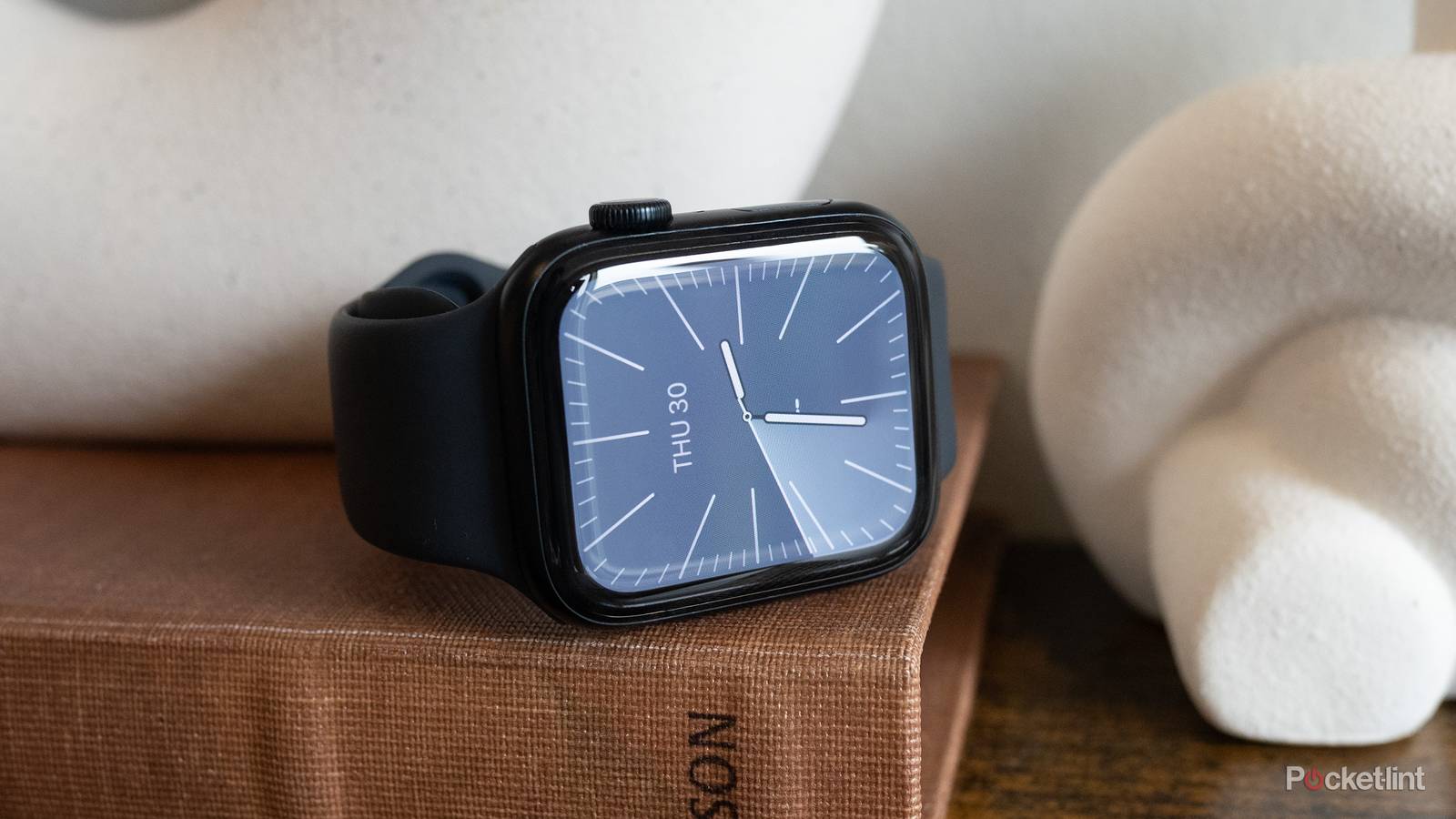 The Apple Watch SE 3 sitting on a book
