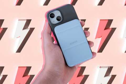 A hand holding an iPhone with an Anker Magnetic Battery Pack attached to it over a background of lightning bolts.