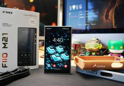 FiiO M21 on a desk with its packaging contents displayed around it.